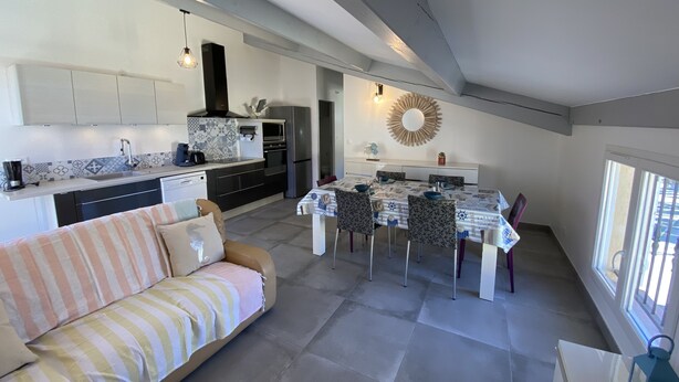 Een moderne keuken met een eethoek, een bank en een groot raam.