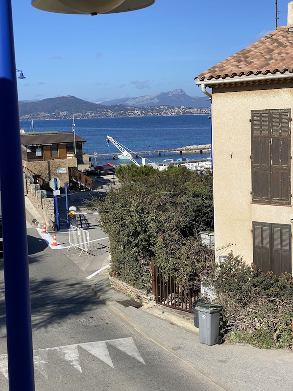 Un carrer costaner amb un edifici que té un balcó i vista al mar.