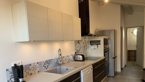 Een moderne keuken met een wit aanrechtblad, zwarte kastjes, een inbouwvaatwasser en een magnetron.