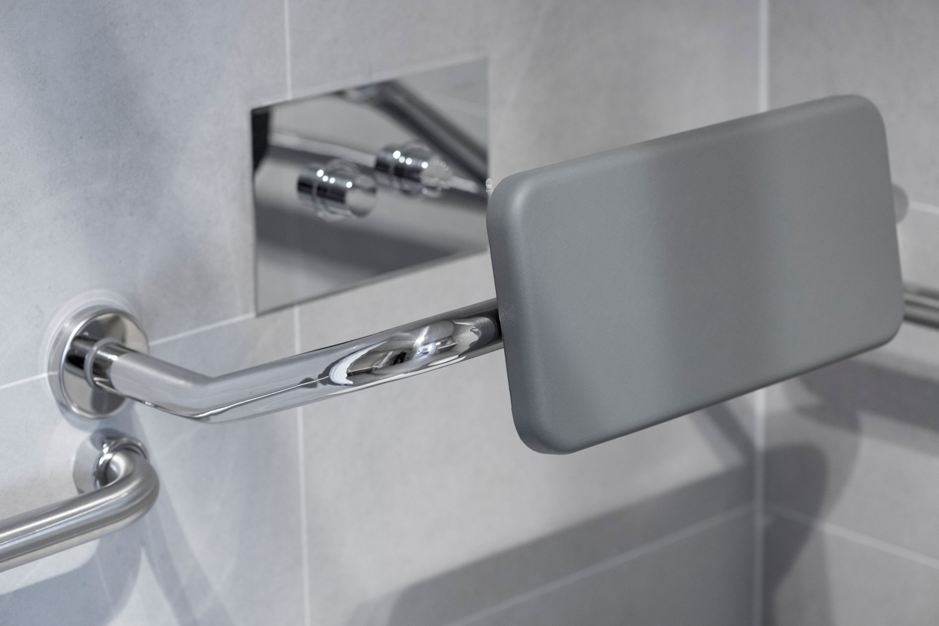 A bathroom with a chrome faucet, a mirror, and a towel rack.