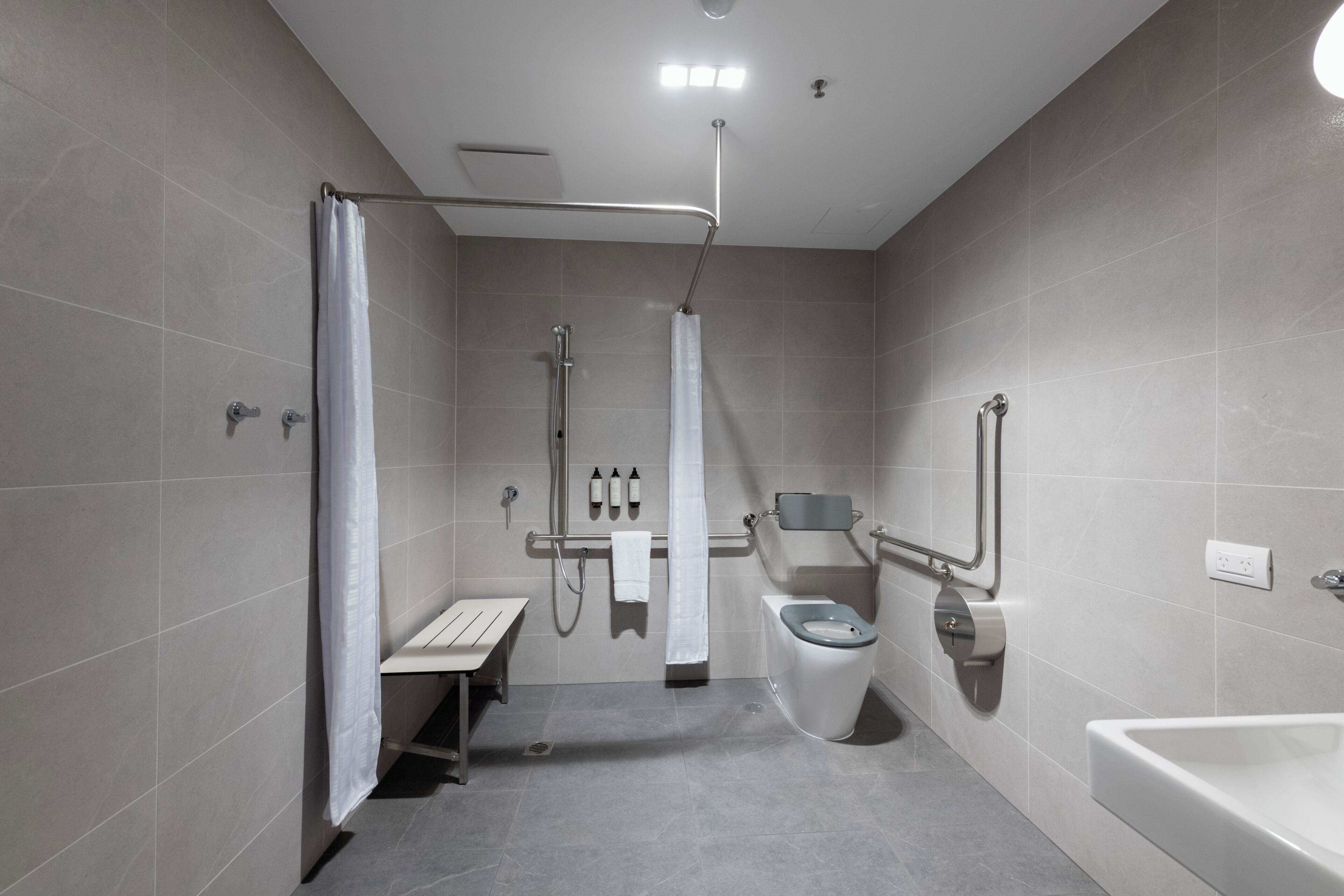 A modern bathroom with a shower, toilet, and sink.
