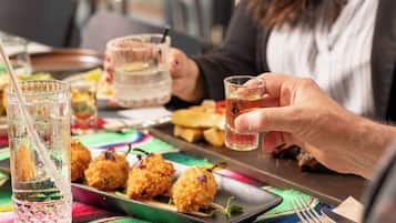 A dining table with a tray of food, a glass of water, and a glass of beer.