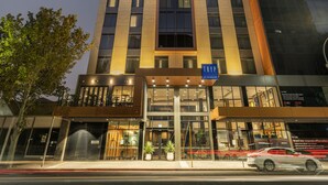Un moderno edificio hotel con un design verticale evidente, un ingresso ben visibile e un cartello che indica che si tratta di un hotel TRYP.