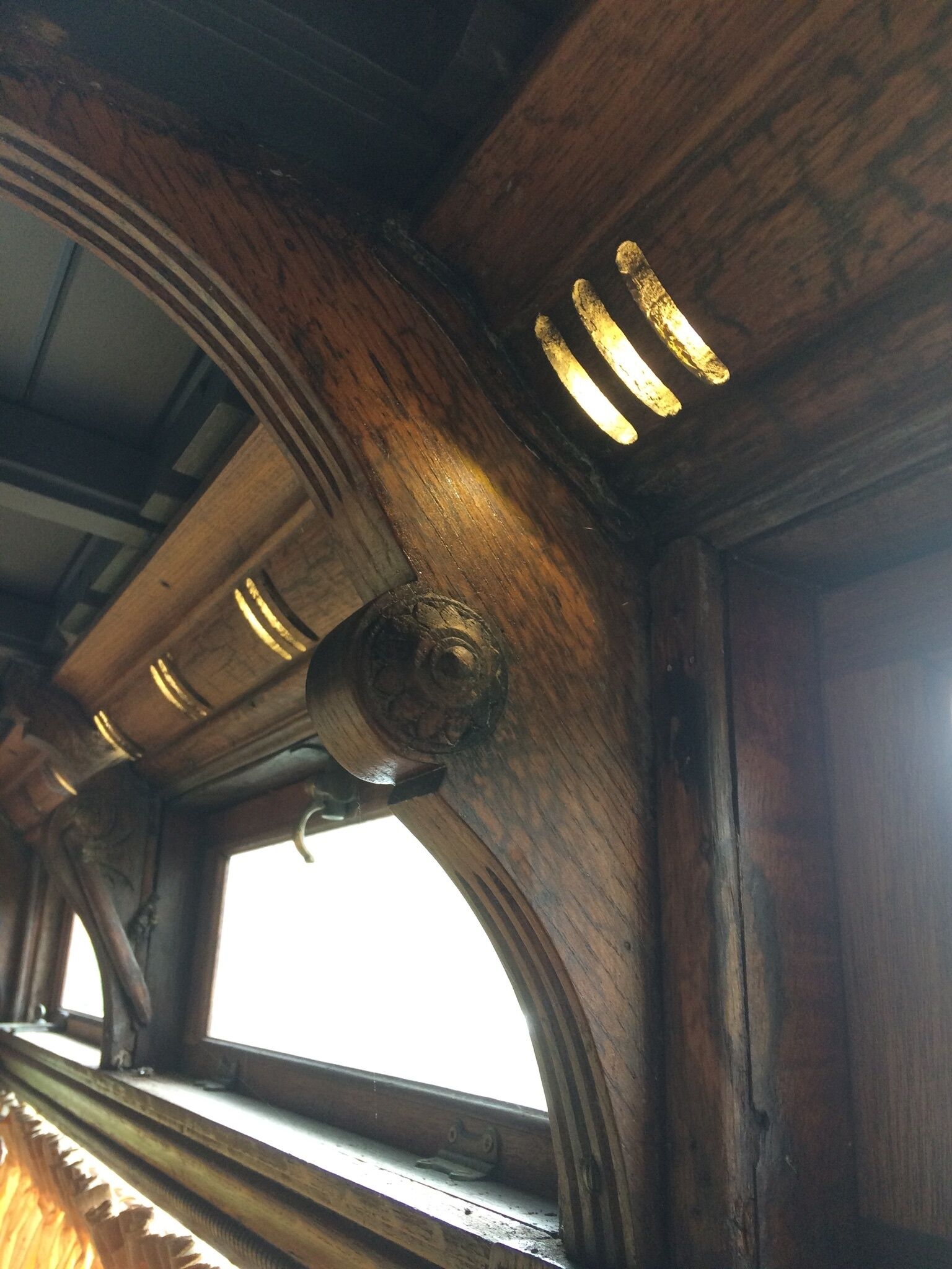 Techo de madera con ventana y lámpara.
