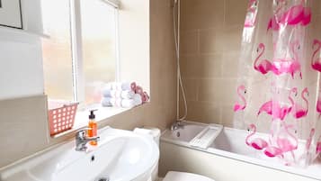 Tina con regadera, secadora de cabello, toallas, papel de baño