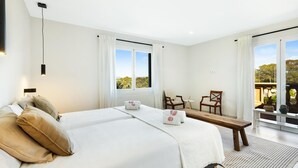 A modern hotel room with a large bed, a small table, two chairs, and a view of the outdoors. - Villa Gioia (Tolleric)