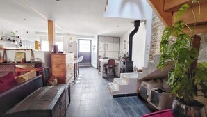A spacious living area with a fireplace, a dining table, and a staircase leading to an upper level. - Quiet town house 2km from Ile de Ré bridge (La Rochelle)
