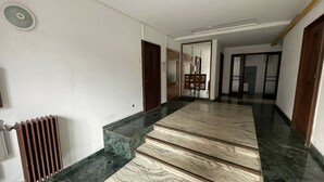 A hallway with a marble staircase, a radiator, and a door leading to another room. - ❤️CityCenter Rosetti Bohemian Rhapsody (București)