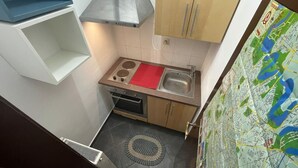 A compact kitchen with a stove, sink, and cabinets. - ❤️CityCenter Rosetti Bohemian Rhapsody (București)