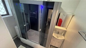A modern bathroom with a glass-enclosed shower, a toilet, and a sink with a mirror. - ❤️CityCenter Rosetti Bohemian Rhapsody (București)