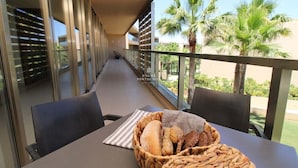 A balcony with a table, chairs, and a basket of bread. - Apartment Villa das Lagoas - By D´alma Portuguesa (Albufeira)