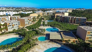 A resort with multiple swimming pools, palm trees, and a view of the sea. - Apartment Villa das Lagoas - By D´alma Portuguesa (Albufeira)