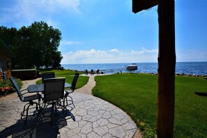 Une terrasse avec des sièges extérieurs et une vue sur l’eau.