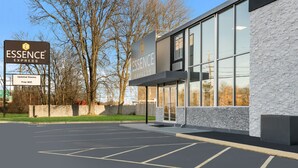 A modern building with a sign indicating 'ESSENCE EXPRESS' and 'Updated Rooms Free Wifi'.