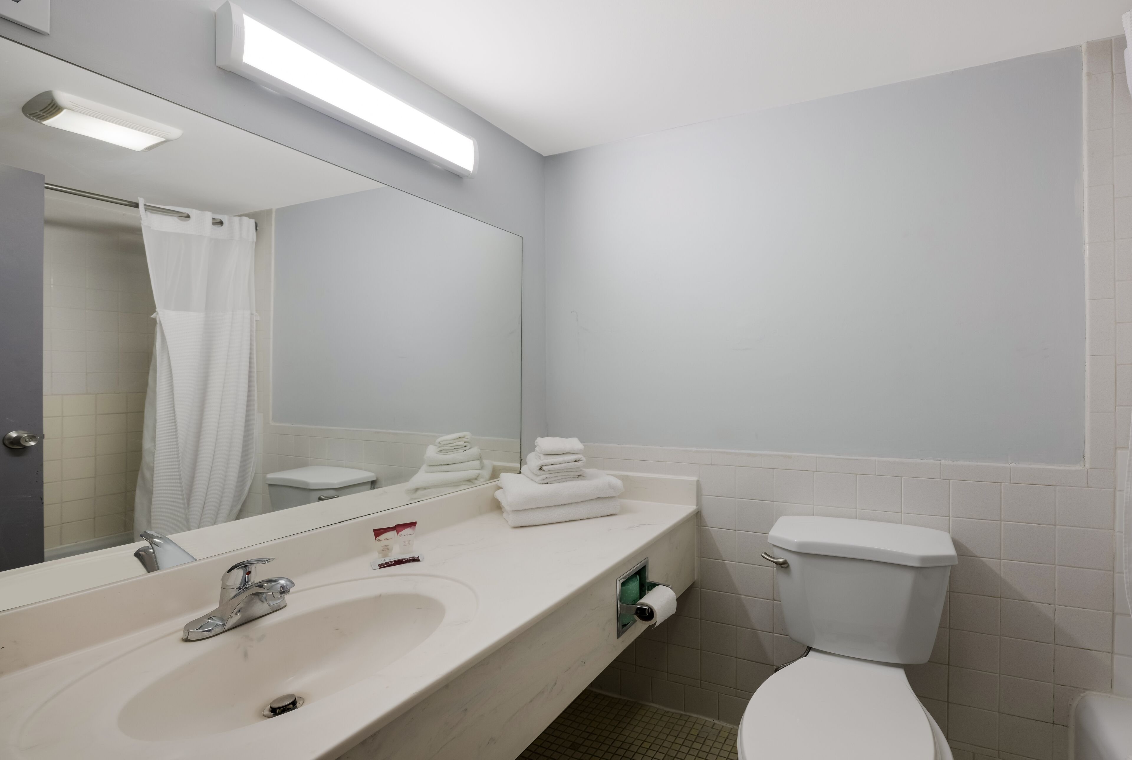 Une salle de bain moderne avec un lavabo blanc, un miroir et des toilettes.