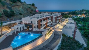 A modern hotel with a swimming pool, multiple balconies, and a view of the sea. - AL BORADA HOMES 3-Bedroom Apartment with Terrace in a Premium Residential Complex in Marbella (Benahavís)