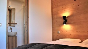 Une chambre à coucher avec une tête de lit en bois, une lampe de chevet et un grand lit.