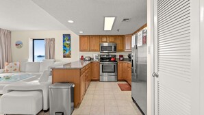A modern kitchen with wooden cabinets, stainless steel appliances, and a white countertop. - Buena Vista 508-Oceanfront 3BR-Walk to Pier- Pool (North Myrtle Beach)
