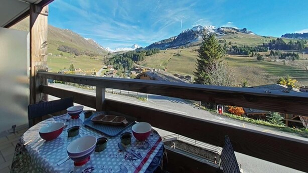 A balcony with a table set for dining, overlooking a mountainous landscape. - 1st floor, view ski slopes, balcony, fireplace or stove, tv, 45m², Le Grand Bornand (Le Grand-Bornand)
