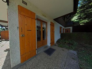 A building entrance with a wooden door and a small porch area.