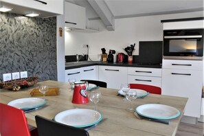 Eine moderne Küche mit weißen Schränken, einer schwarzen Arbeitsplatte und einem eingebauten Backofen.