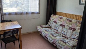 A small room with a wooden table and a patterned sofa. - 300m from ski slopes, Ground floor, tv, 21m², Orcières Merlette 1850 (Orcières)