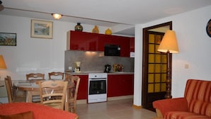 A compact living space with a kitchen, dining area, and a sofa. - 1st floor, balcony, tv, ski locker, 77m², Le Grand Bornand (Le Grand-Bornand)