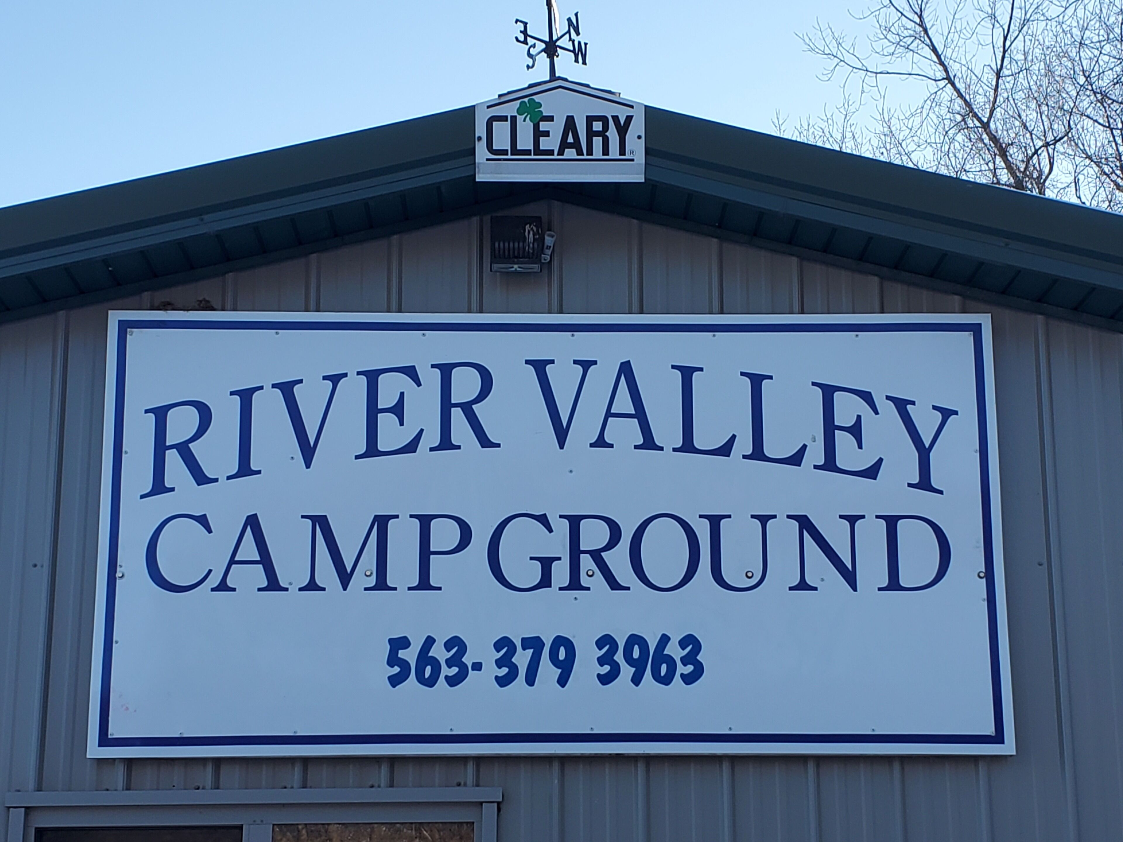 A sign for River Valley Campground with a contact number.