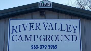 A sign for River Valley Campground with a contact number.
