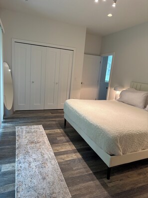 A bedroom with a large bed, a wardrobe, and a bedside table. - CHIC MODERN HOUSE ON THE VERY DESIRABLE LOCATION IN DOWNTOWN WAYZATA  (Wayzata)