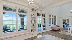 A spacious room with large windows, a built-in bench, and a fireplace. - Luxurious Spacious Chateau on Table Rock Lake with Hot Tub (Ridgedale)