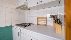 A kitchen with white cabinets, a stove, and a knife block. - 1st floor, view mountain, balcony, ski locker, 34m², Valmorel (Valmorel)