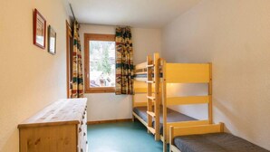 A dormitory room with bunk beds, a wooden desk, a window with curtains, and framed pictures on the wall. - 1st floor, view mountain, balcony, ski locker, 34m², Valmorel (Valmorel)