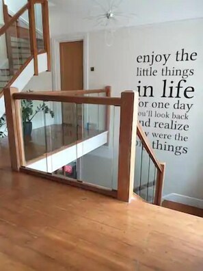 Una escalera con cerramiento de vidrio y una cita inspiradora en la pared.