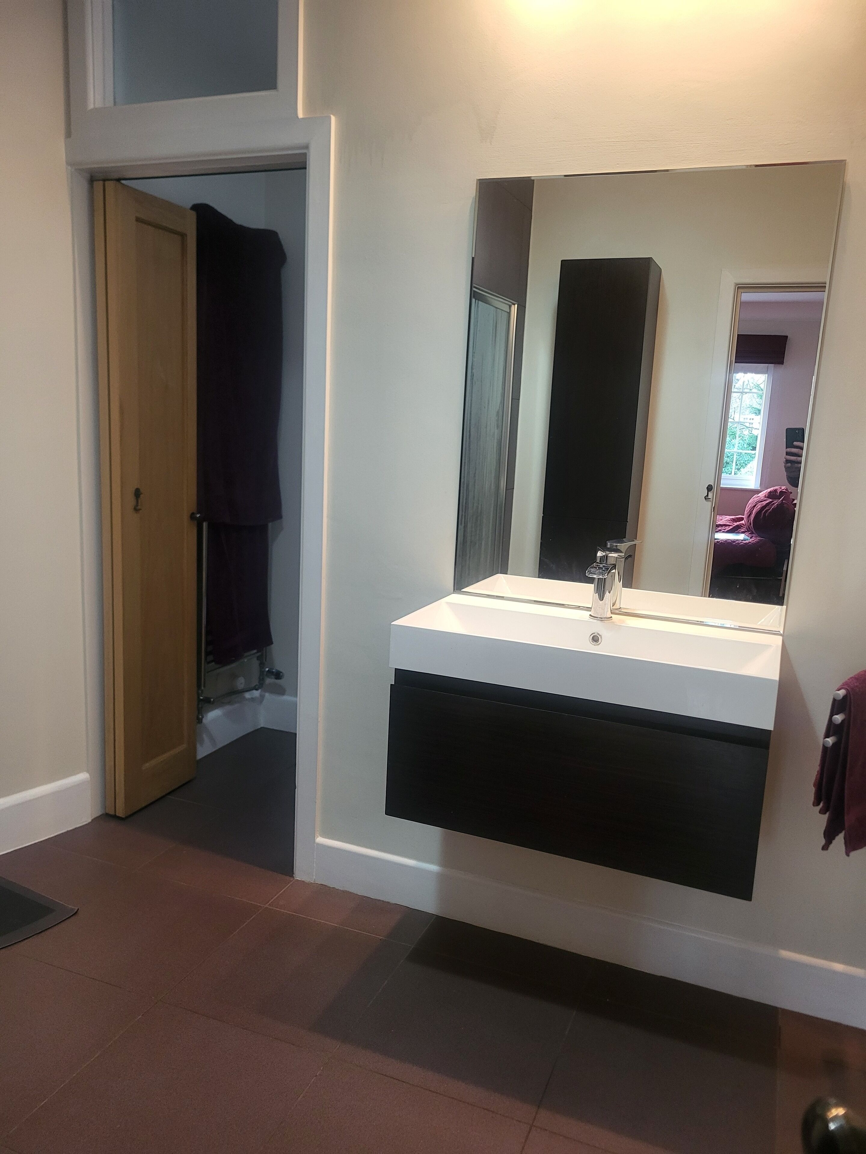 A bathroom with a white sink, a mirror, and a towel rack.