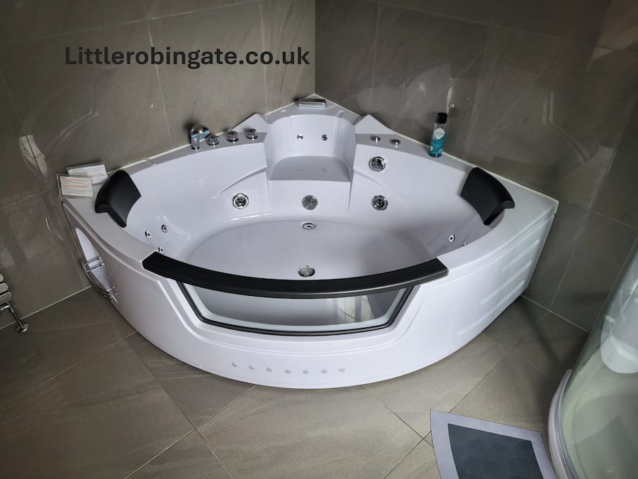 A modern bathroom with a large, curved jacuzzi tub, a glass shower enclosure, and a tiled floor.