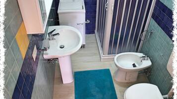 Apartamento básico | Banheiro | Chuveiro, chuveiro com efeito de chuva, bidê, toalhas de banho