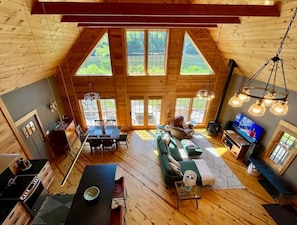 Un loft spacieux avec de hauts plafonds, de grandes fenêtres, un coin salon confortable et une cuisine.
