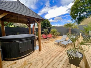 A wooden deck with a hot tub, lounge chairs, and potted plants. - LoveRoom by Gîtes d'Armor (Plelo)