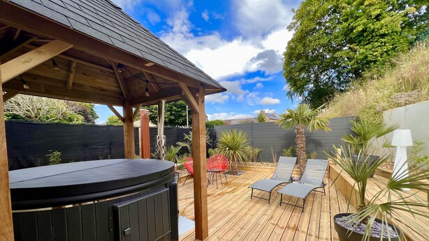 A wooden deck with a hot tub, lounge chairs, and potted plants. - LoveRoom by Gîtes d'Armor (Plelo)