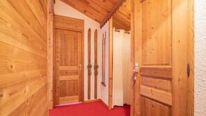 Un pasillo con puertas de madera y alfombra roja.