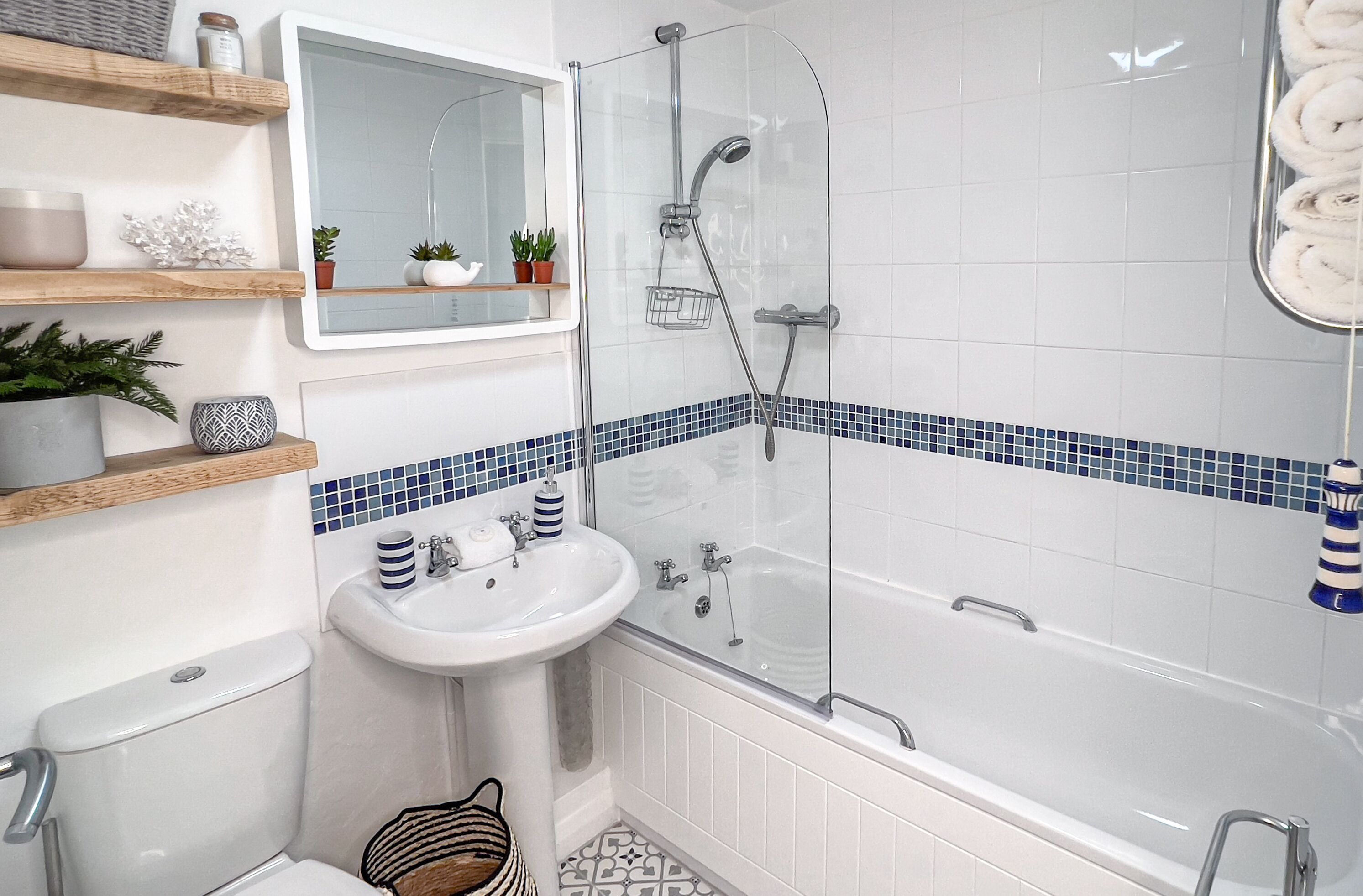 A bathroom with a glass-enclosed shower, a white sink, and a bathtub.