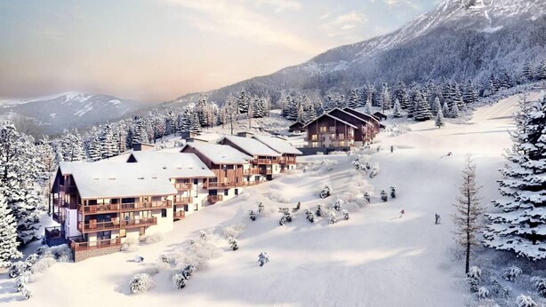 A snow-covered lodge with multiple wooden buildings, surrounded by snow-laden trees and mountains in the background. - 380m from shops, 4th floor, view mountain, balcony, parking, ski locker, 85m², Valmorel (Les Avanchers-Valmorel)