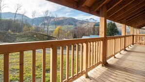 A wooden deck with a view of a mountainous landscape. - 380m from shops, 4th floor, view mountain, balcony, parking, ski locker, 85m², Valmorel (Les Avanchers-Valmorel)