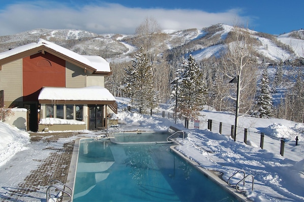 Uma área de piscina com vista para montanhas cobertas de neve.