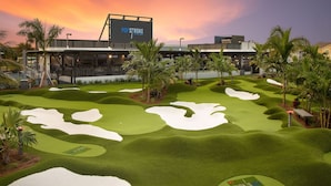 Ein Golfplatz mit einem modernen Gebäude im Hintergrund.