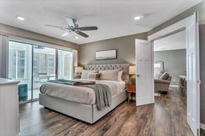 A spacious bedroom with a large bed, a ceiling fan, and a view of the city through large windows. - Family-Friendly 2BR Condo Near Table Rock Lake & Branson Strip Pools + King Beds (Branson)