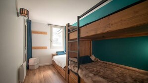 A bunk bed room with a window, a radiator, and a wall-mounted lamp. - 50m from ski slopes, 1st floor, view mountain, balcony, tv, ski locker, 34m², Valmorel (Valmorel)