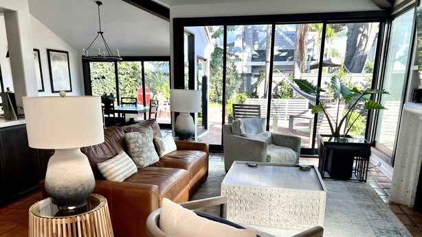 A modern living room with a leather sofa, a round wooden table, and a wicker chair. - 2 minute walk to Del Mar Beach! (Del Mar)