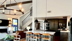A modern kitchen with a central island, bar stools, and a dining table with chairs. - 2 minute walk to Del Mar Beach! (Del Mar)